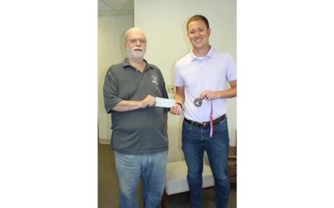 2024 McPherson County All Schools Day (Physical) Button Hunt Winner Nikolous Rempe receives his check for $250 from Button Hunt Chair Lucky Kidd.