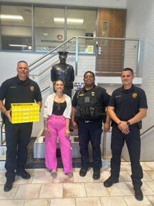 An Envista employee presents gifts to three members of the Hutchinson police department.