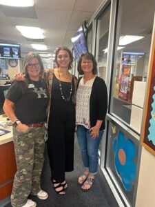 An ENvista Employee poses for the picture with two Hutchinson Teachers.