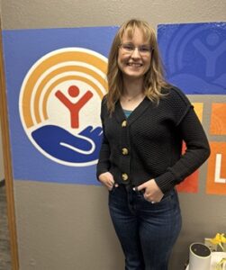 Tasha Miller, a woman with blonde hair and glasses, wearing a black sweater and Jeans.