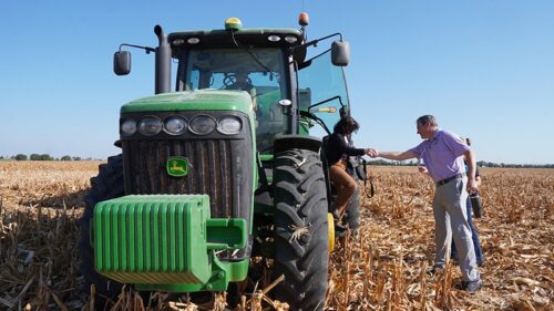 K-State Vice President for Research Hans Coetzee helps a tour participant out of a tractor at the Flickner Innovation Farm.Photo Credit: KSRE